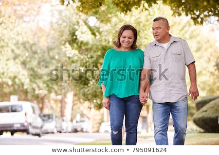 senior-couple-walking-along-suburban-450w-795091624.jpg