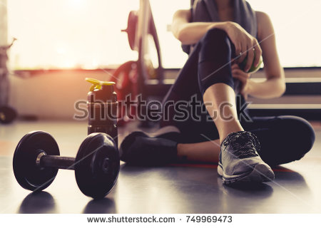 stock-photo-woman-exercise-workout-in-gym-fitness-breaking-relax-holding-apple-fruit-after-training-sport-with-749969473.jpg