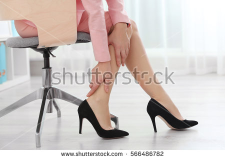 stock-photo-woman-suffering-from-leg-pain-in-office-566486782.jpg