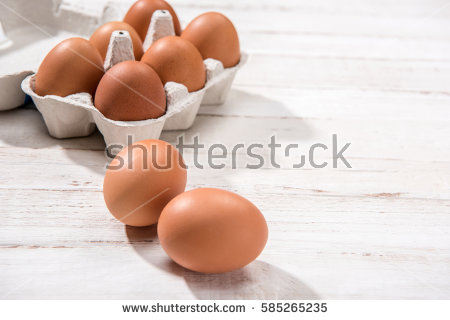 stock-photo-close-up-view-of-raw-chicken-eggs-in-egg-box-on-white-wooden-background-585265235.jpg