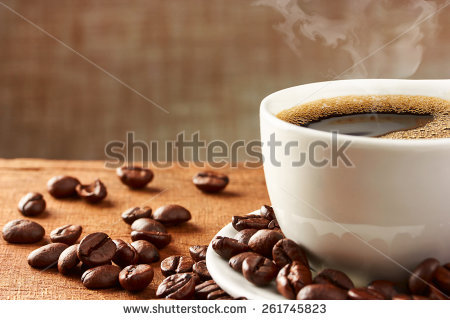 stock-photo-coffee-cup-and-coffee-beans-on-table-261745823.jpg