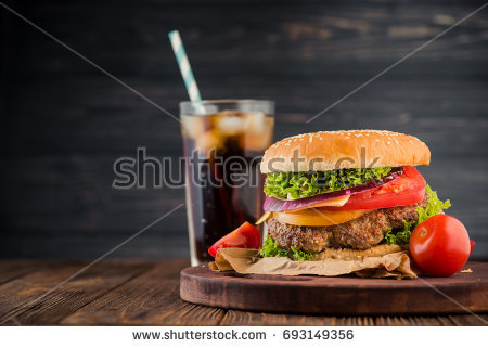 stock-photo-delicious-fresh-burger-with-tomato-and-cheese-and-cola-glass-on-background-fastfood-concept-dinner-693149356.jpg