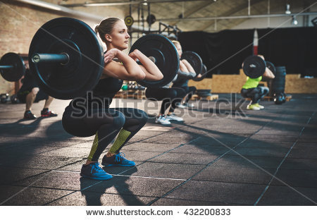 stock-photo-fit-young-woman-lifting-barbells-looking-focused-working-out-in-a-gym-with-other-people-432200833.jpg