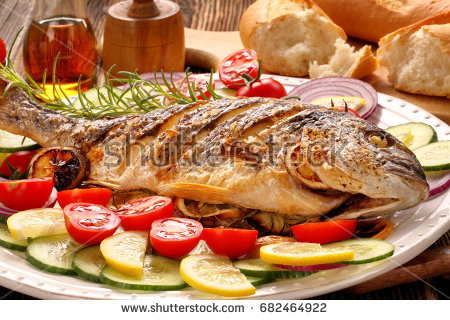 stock-photo-roasted-dorada-fish-with-vegetables-on-wooden-background-682464922.jpg